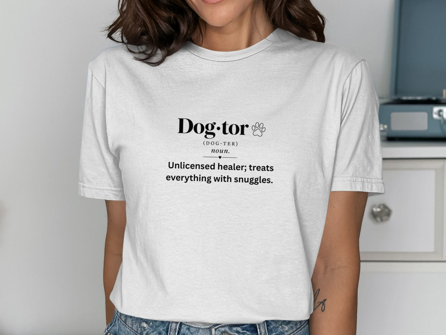 White t-shirt with black text defining "Dog-tor" as an unlicensed healer who treats with snuggles.