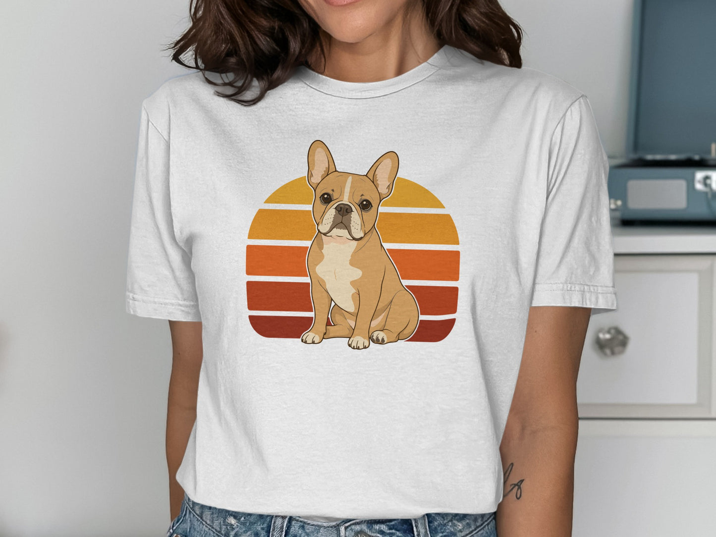 French bulldog sitting in front of a retro sunset graphic on a white t-shirt.