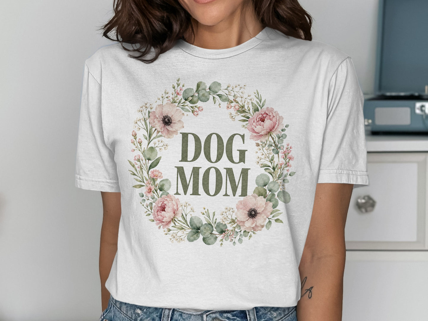 White t-shirt with "DOG MOM" text within a floral wreath design.