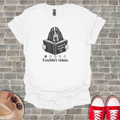 White t-shirt with a dog reading a book titled "Staying Off Furniture" with "Couldn't relate."