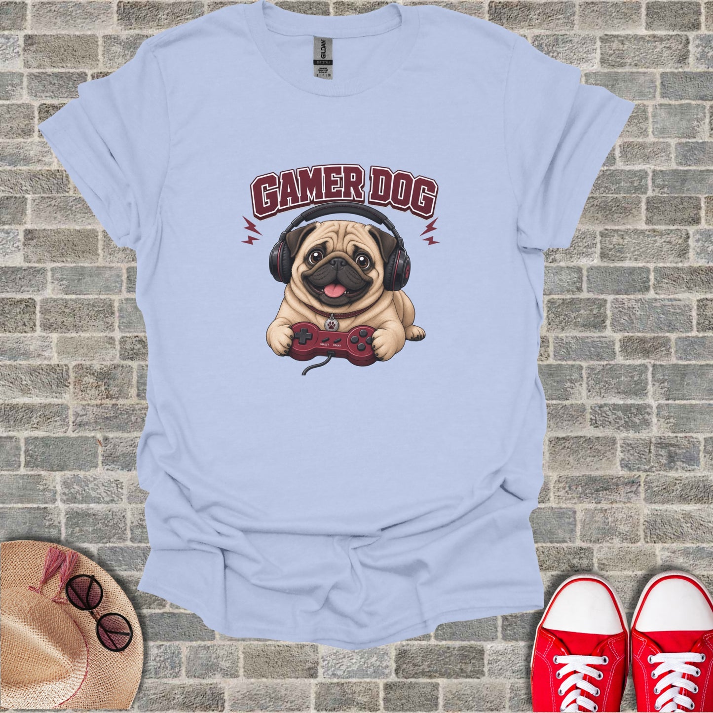 Light blue t-shirt with cartoon pug wearing headphones and holding a video game controller.
