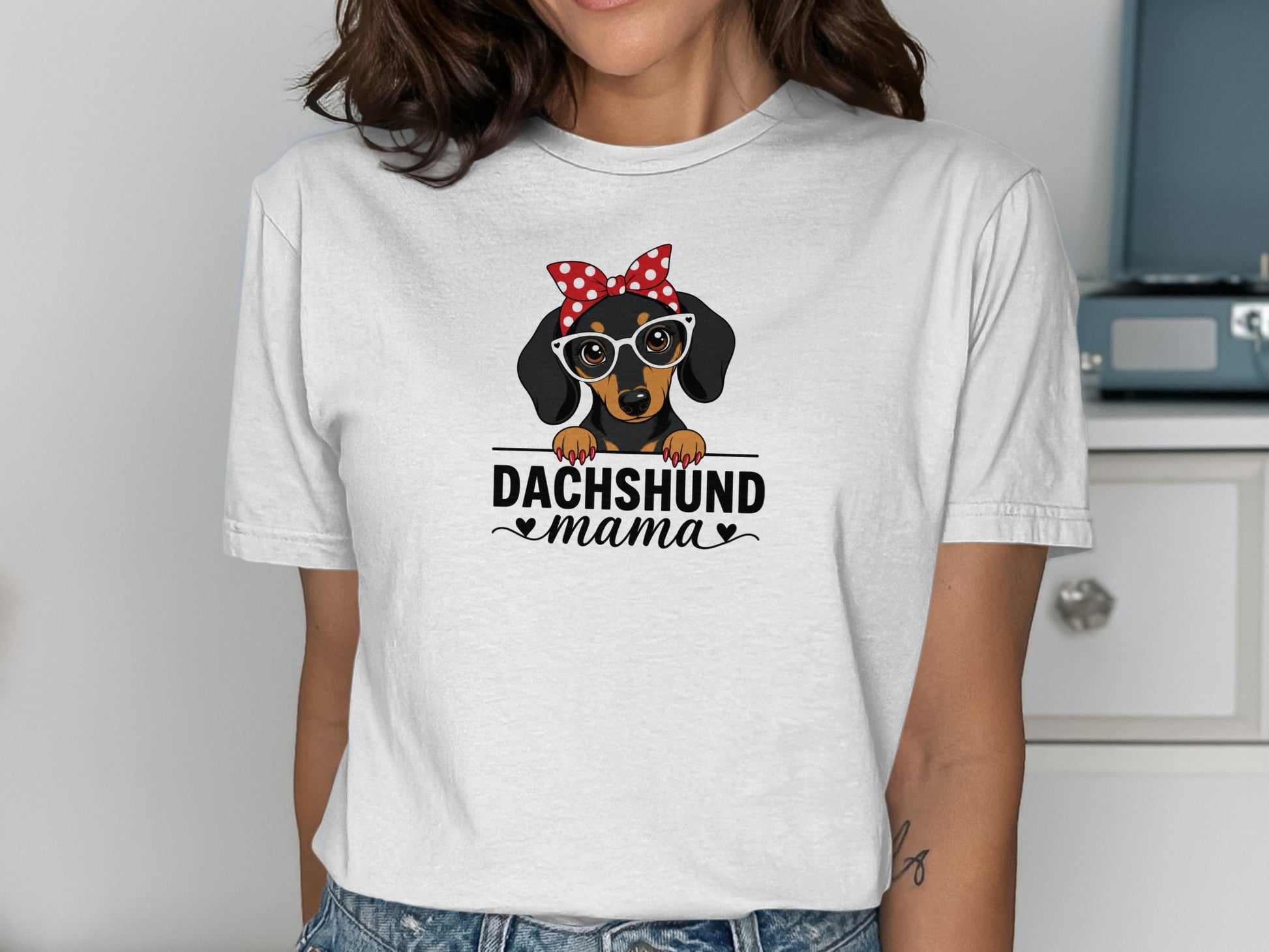 Dachshund mama text on a white t-shirt with a cartoon dachshund wearing glasses and a bandana.