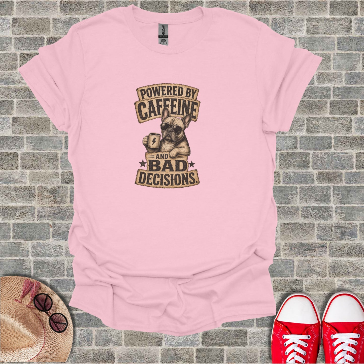 Pink t-shirt with French bulldog graphic reading "POWERED BY CAFFEINE AND BAD DECISIONS".