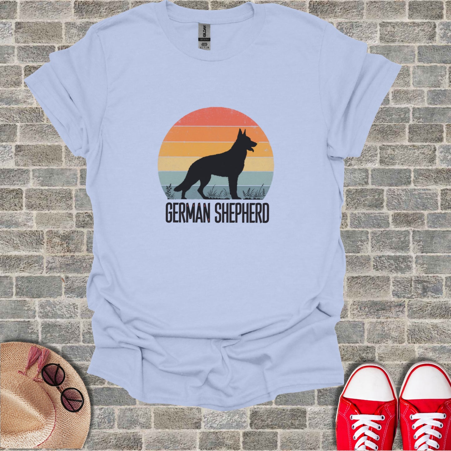 Light blue t-shirt with a German Shepherd silhouette against a sunset graphic.
