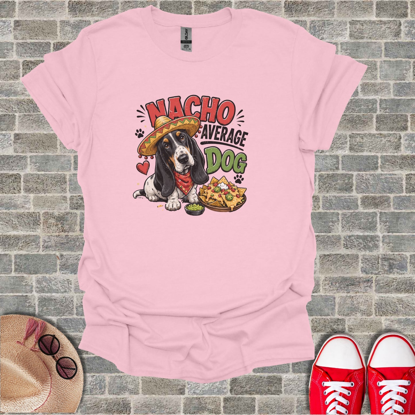 Pink t-shirt with a dog in a sombrero and nachos graphic and text "Nacho Average Dog".