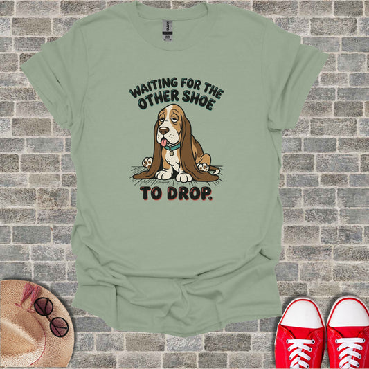 T-shirt with text "Waiting for the other shoe to drop" and a sad dog graphic.