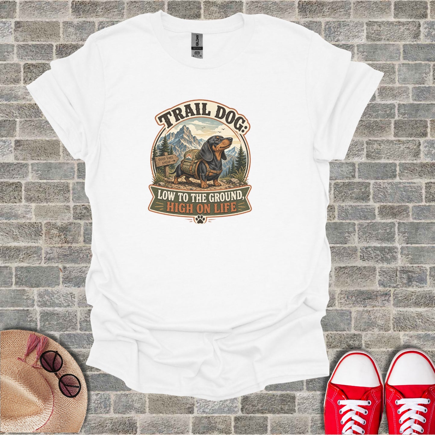 White t-shirt with "Trail Dog: Low to the ground, high on life" and dachshund graphic.