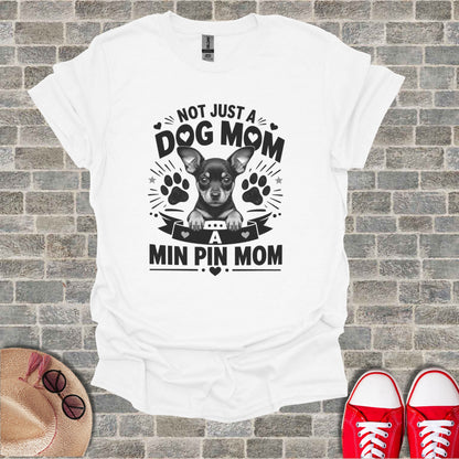 White t-shirt with "Not Just a Dog Mom, A Min Pin Mom" text and a chihuahua graphic.