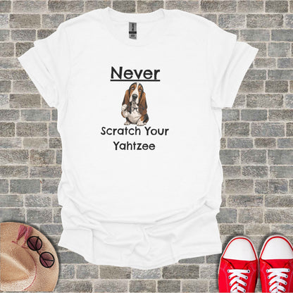 White t-shirt with Basset Hound wearing glasses and text "Never Scratch Your Yahtzee".