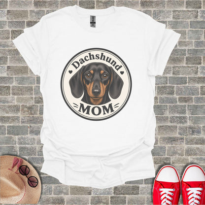 White t-shirt with a Dachshund Mom graphic featuring a dachshund's face.