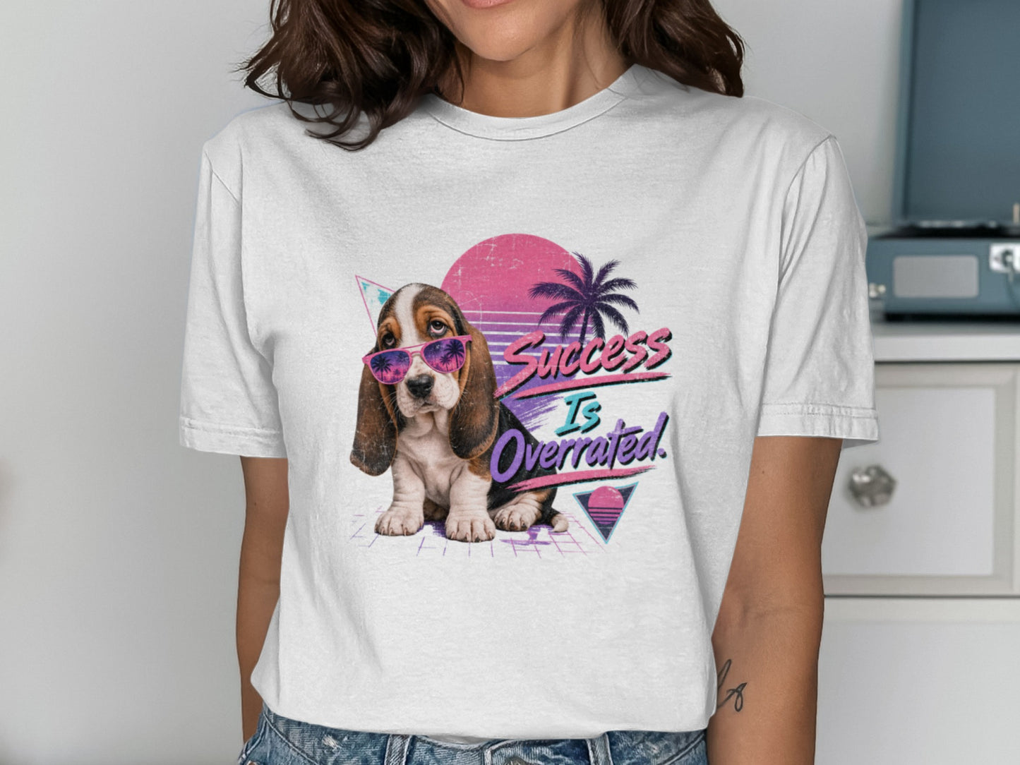 Basset hound in sunglasses with "Success Is Overrated" text, 80s retro design.