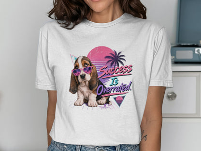 Basset hound in sunglasses with "Success Is Overrated" text, 80s retro design.