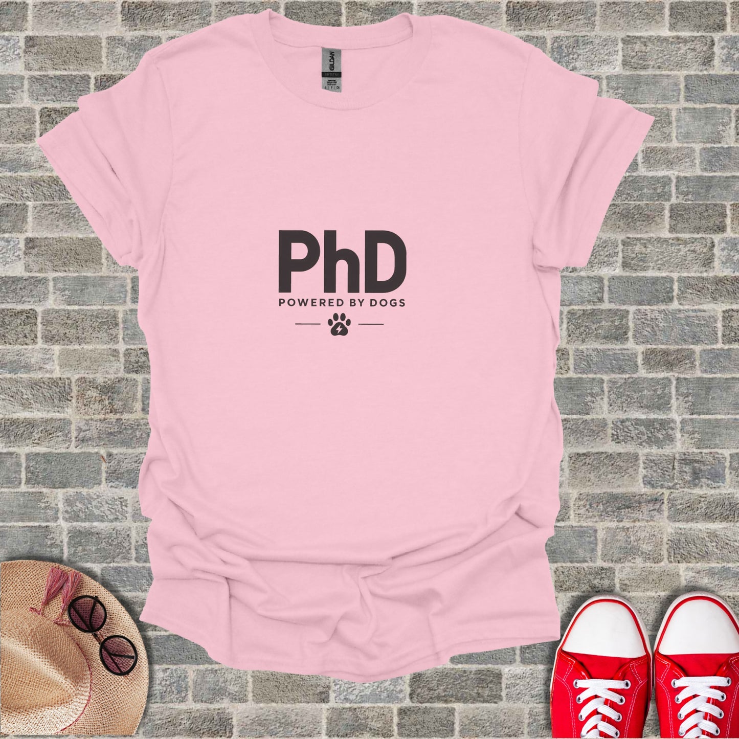 Pink t-shirt with "PhD Powered By Dogs" and paw print logo.