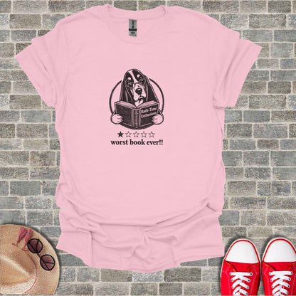 Pink t-shirt with a cartoon dog reading a book.