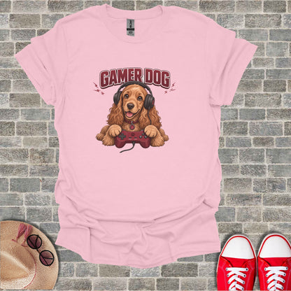 Pink t-shirt with a cartoon dog wearing headphones holding a video game controller.