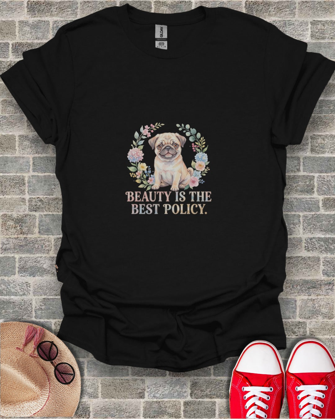Black t-shirt with pug and floral wreath graphic, text "Beauty is the best policy".