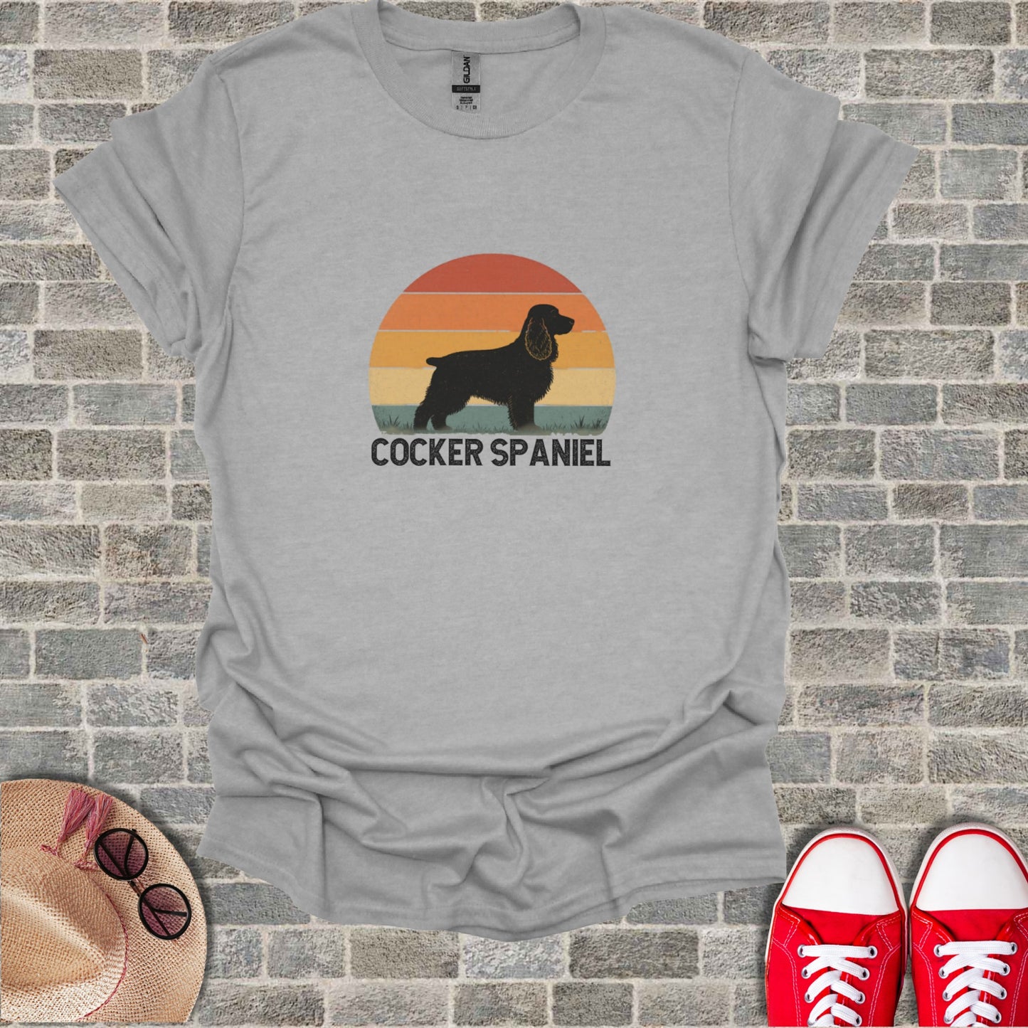 Grey t-shirt with "COCKER SPANIEL" text and silhouette on sunset background.