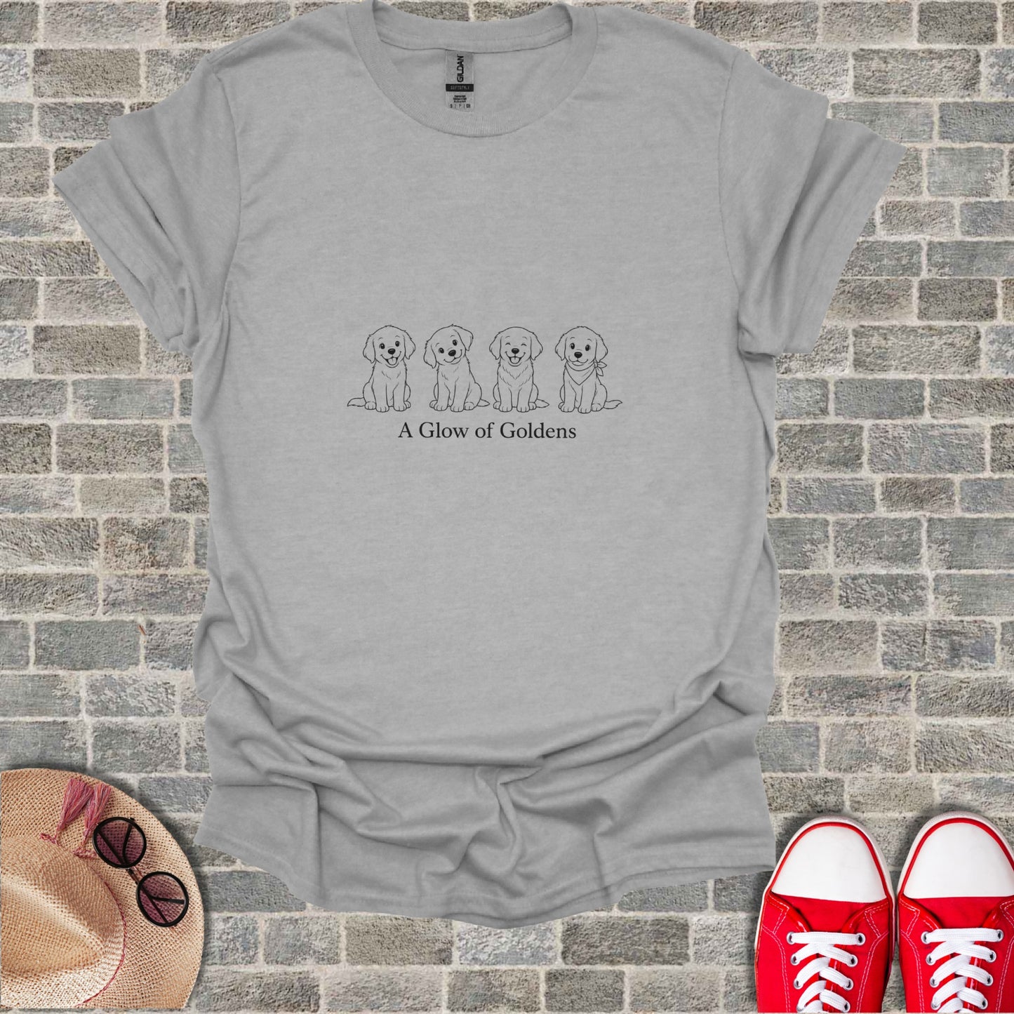 Grey t-shirt with line drawing of four puppies and text "A Glow of Goldens".