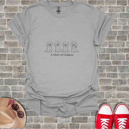 Grey t-shirt with line drawing of four puppies and text "A Glow of Goldens".