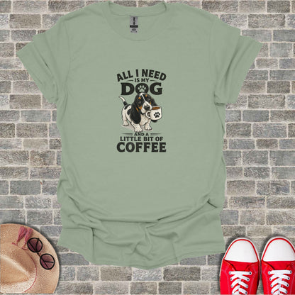 T-shirt with cartoon dog holding a coffee mug and text "All I need is my dog and a little bit of coffee".