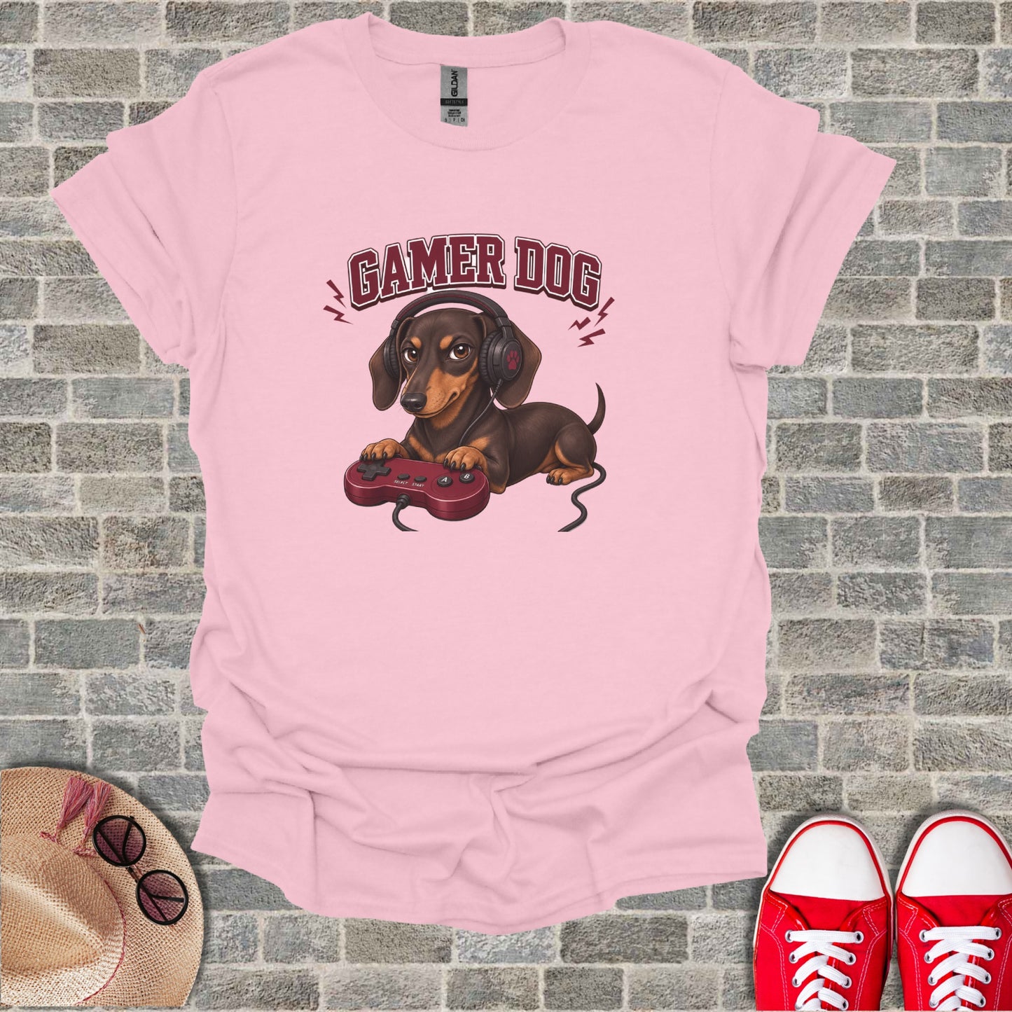 Pink t-shirt with dachshund wearing headphones and holding a game controller.