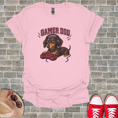 Pink t-shirt with dachshund wearing headphones and holding a game controller.