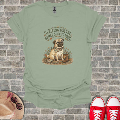 Green t-shirt with pug dog wearing bandana, waiting for shoe to drop graphic.