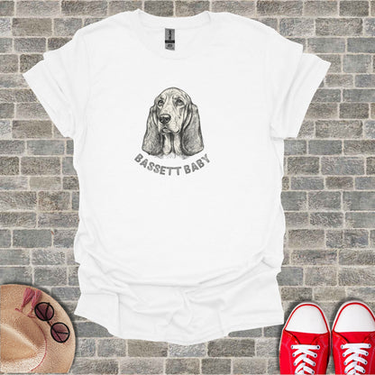 White t-shirt with a sketch of a basset hound and "BASSETT BABY" text.