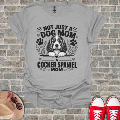 Grey t-shirt with "Not Just A Dog Mom" and Cocker Spaniel graphic.