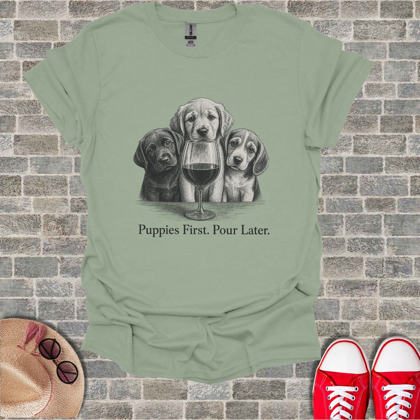 T-shirt with sketch of three puppies and wine glass, text "Puppies First. Pour Later."