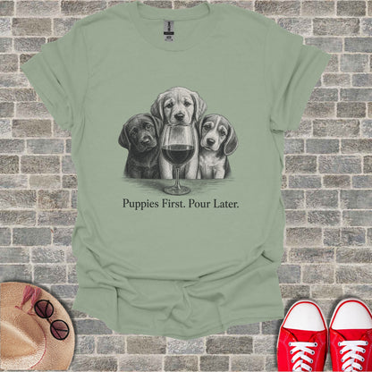 T-shirt with sketch of three puppies and wine glass, text "Puppies First. Pour Later."