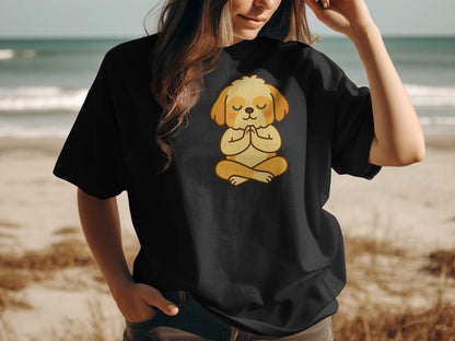 Black t-shirt with a cartoon dog meditating on a beach.