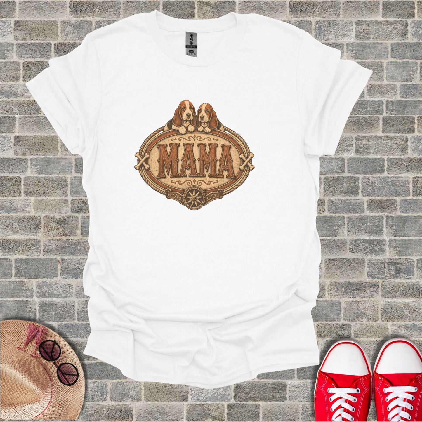 White t-shirt with a distressed oval graphic featuring two Basset Hound puppies and the word "Mama".