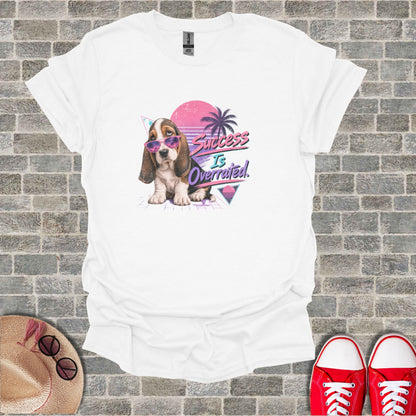 White t-shirt with a retro dog graphic and "Success Is Overrated" text.