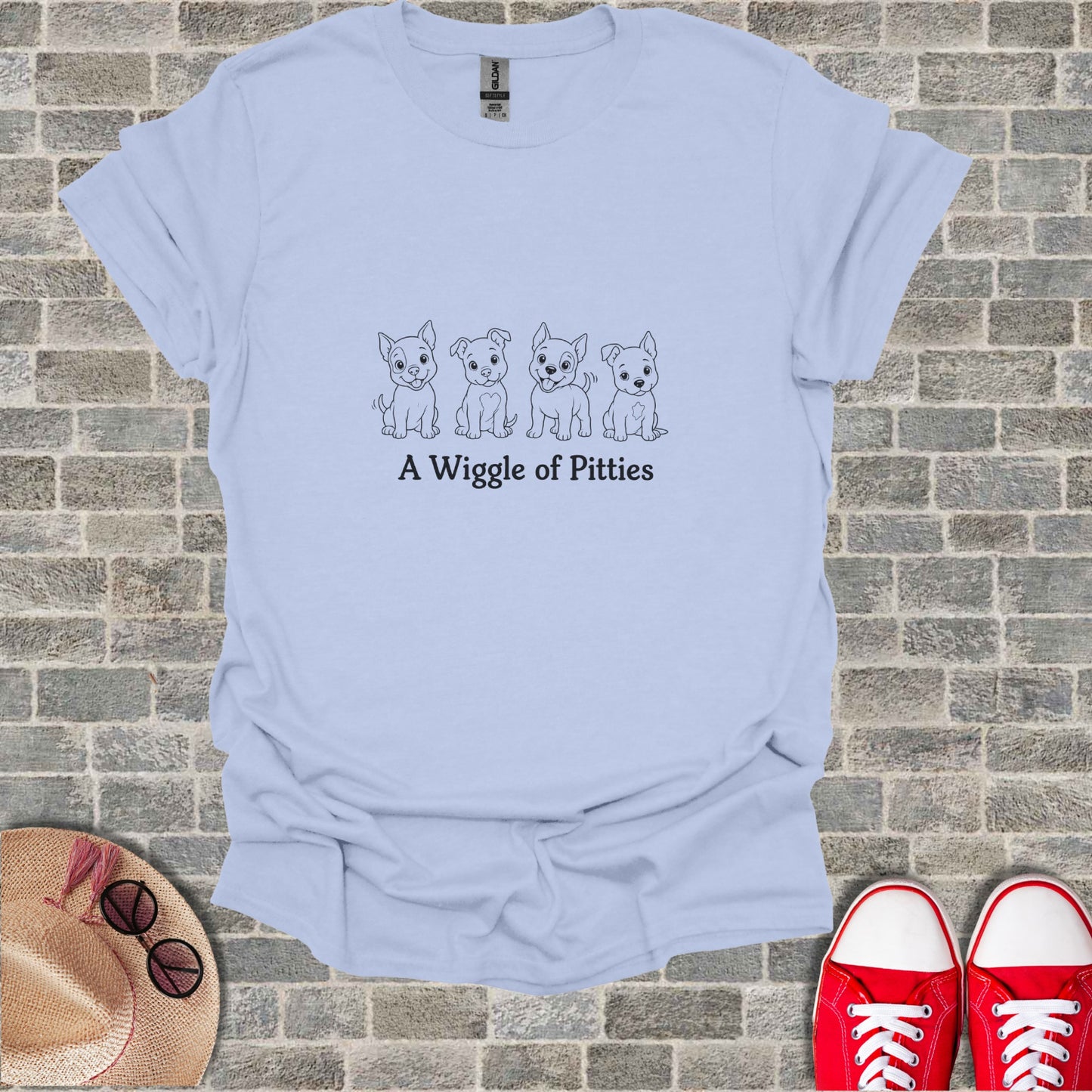 Light blue t-shirt with a line drawing of four puppies and the text "A Wiggle of Pitties".