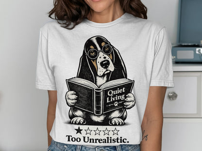 Basset hound wearing glasses reads a book titled "Quiet Living" on a t-shirt.