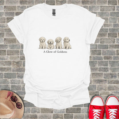 White t-shirt with a line of four golden retriever puppies and text "A Glow of Goldens".