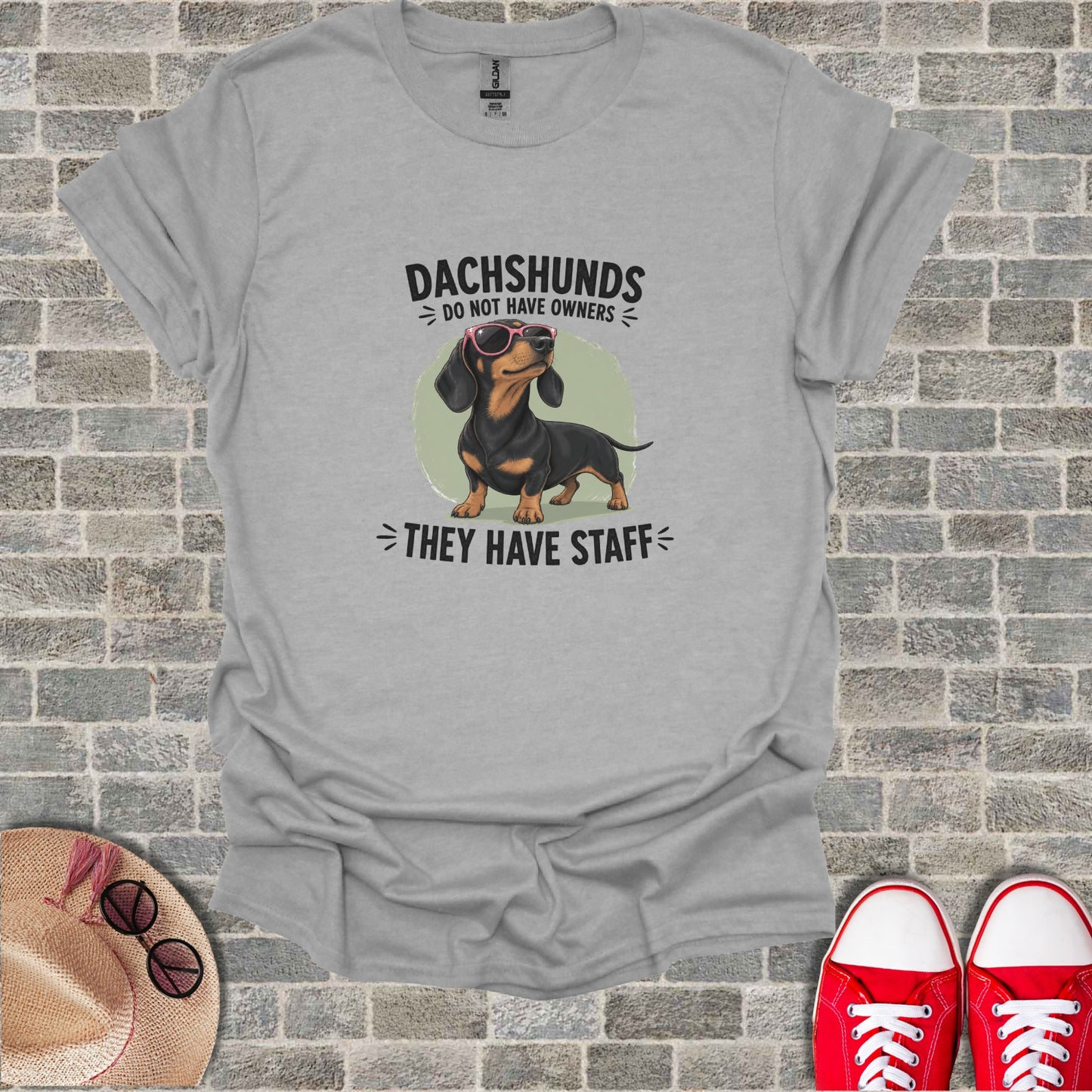 Gray t-shirt with dachshund wearing sunglasses and text "Dachshunds do not have owners".