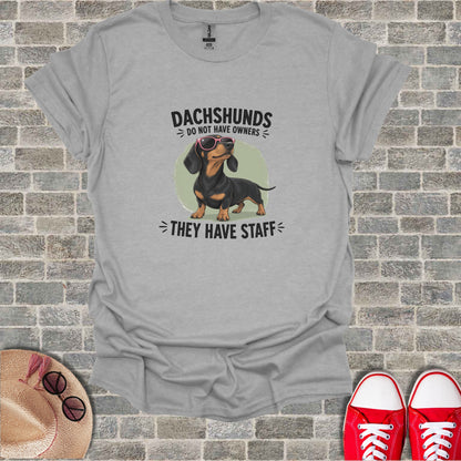 Gray t-shirt with dachshund wearing sunglasses and text "Dachshunds do not have owners".
