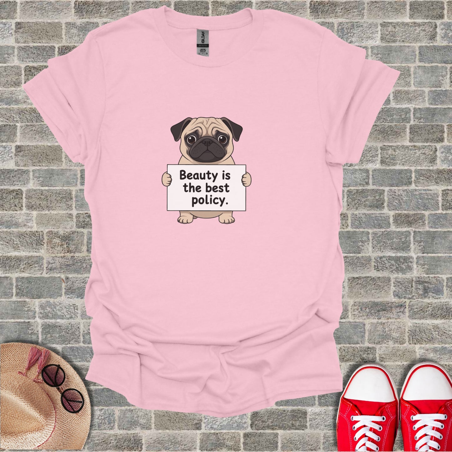 Pink t-shirt with a pug holding a sign that says "Beauty is the best policy."