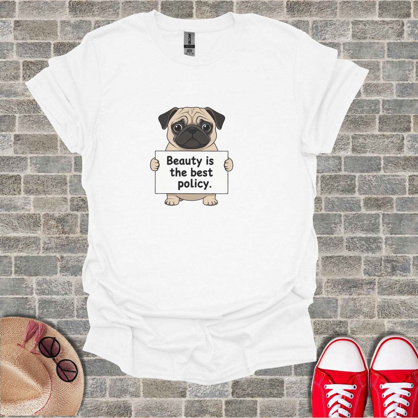 White t-shirt with pug holding sign that says "Beauty is the best policy."