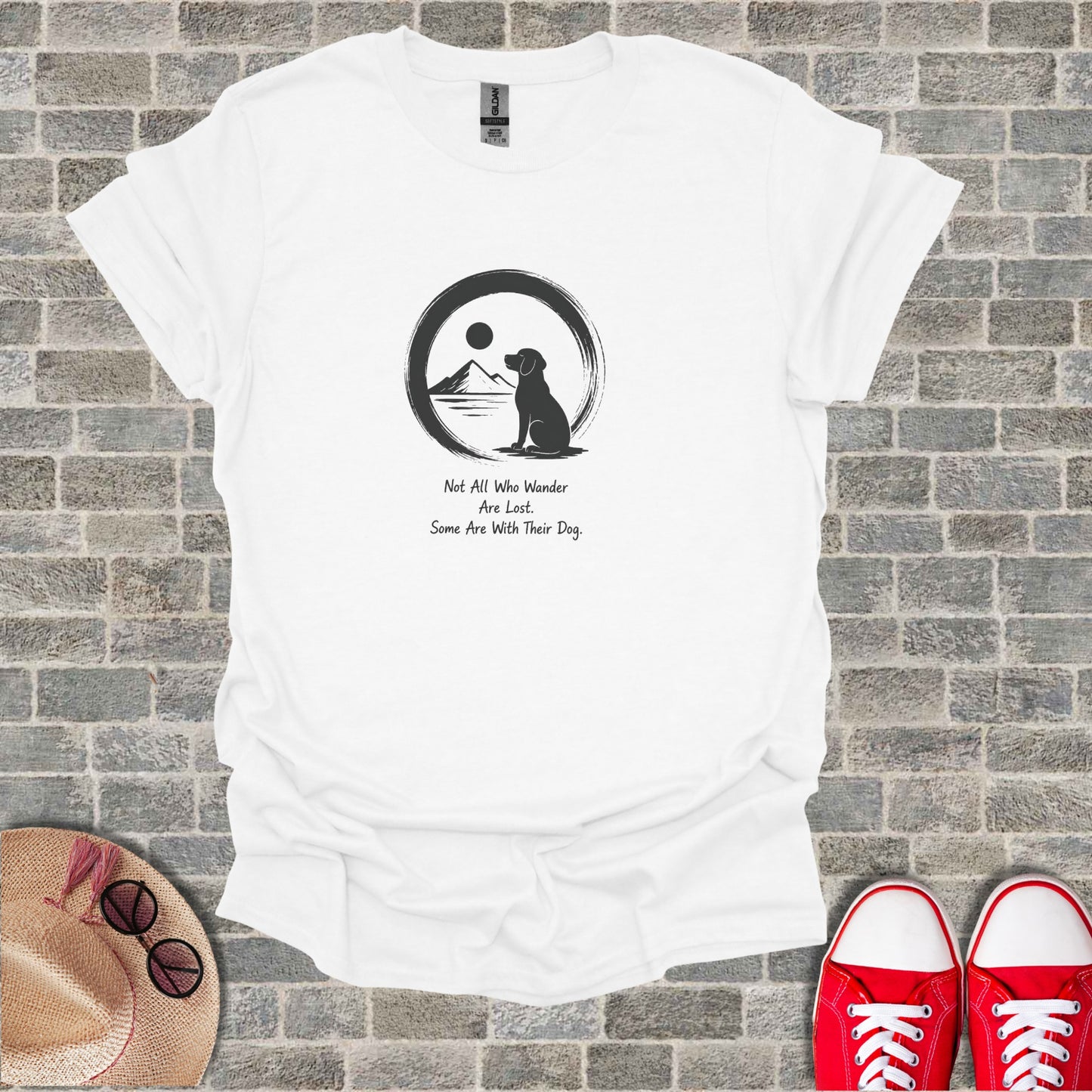 White t-shirt with black silhouette of a dog in a circle with a mountain and sun, text above.