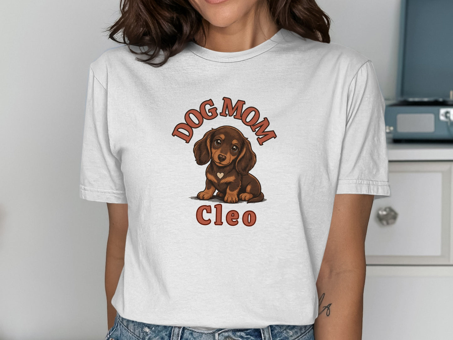 White t-shirt with dachshund graphic and "Dog Mom Cleo" text.