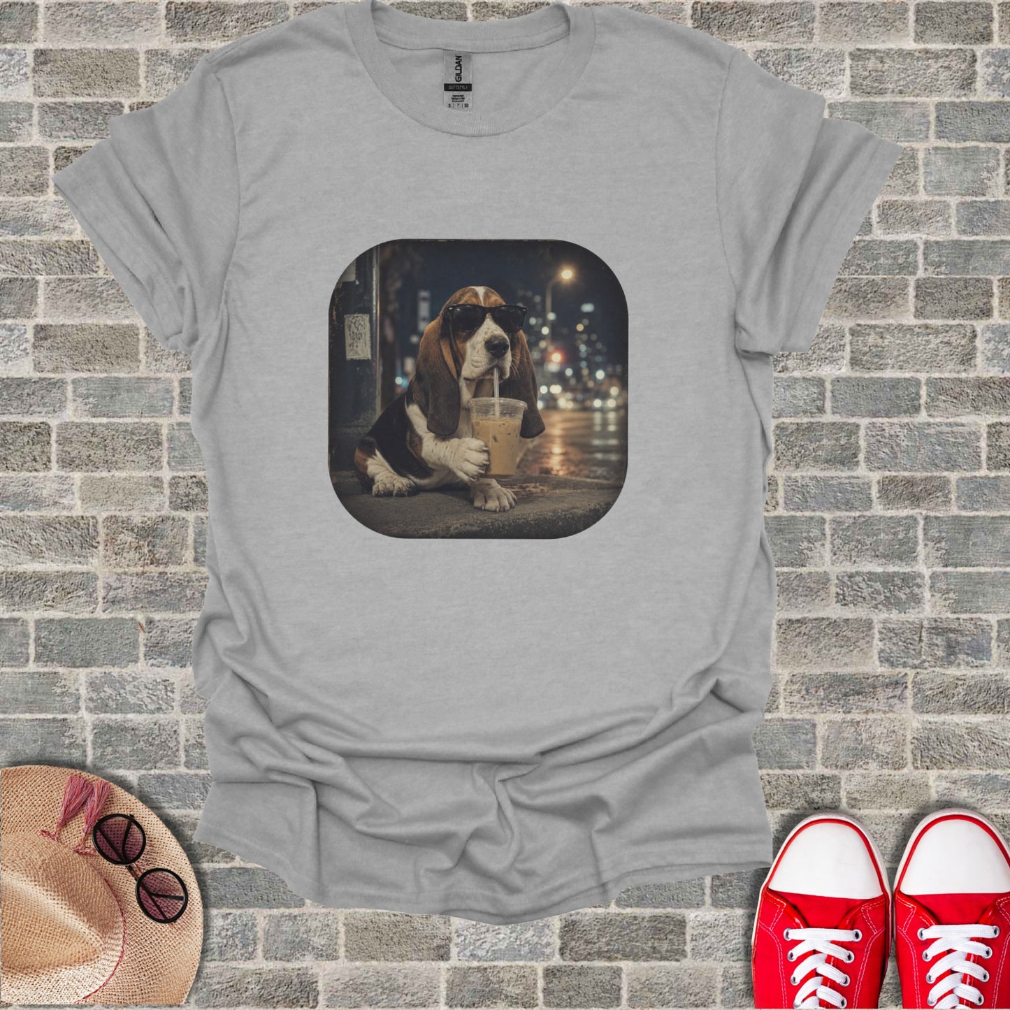 Basset hound wearing sunglasses drinks from a to-go cup at night.