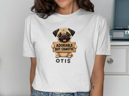 White t-shirt with a pug holding a sign that says "ADORABLE BUT CHAOTIC OTIS".