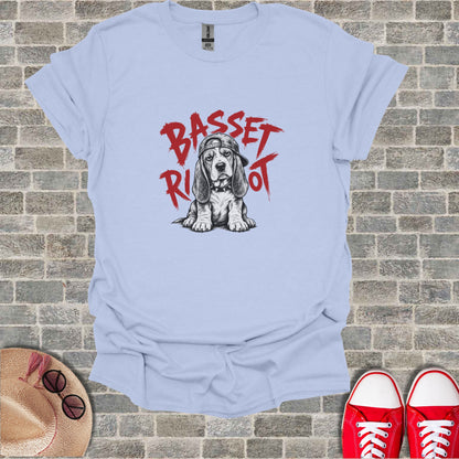 Basset Hound wearing a baseball cap with "Basset Riot" text.