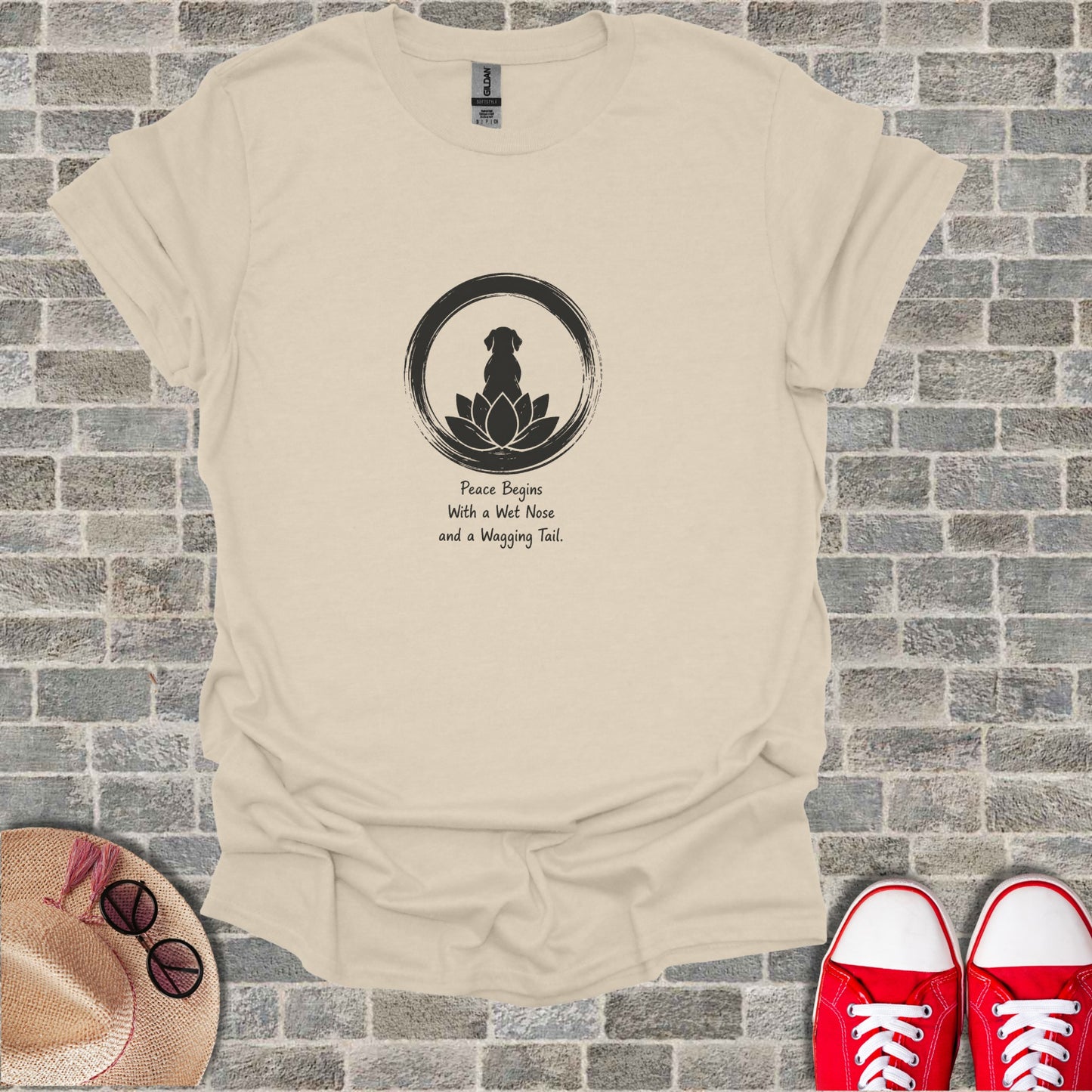 Beige t-shirt with black dog silhouette, lotus, and quote "Peace Begins With a Wet Nose and a Wagging Tail."