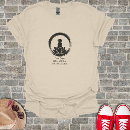 Beige t-shirt with black dog silhouette, lotus, and quote "Peace Begins With a Wet Nose and a Wagging Tail."
