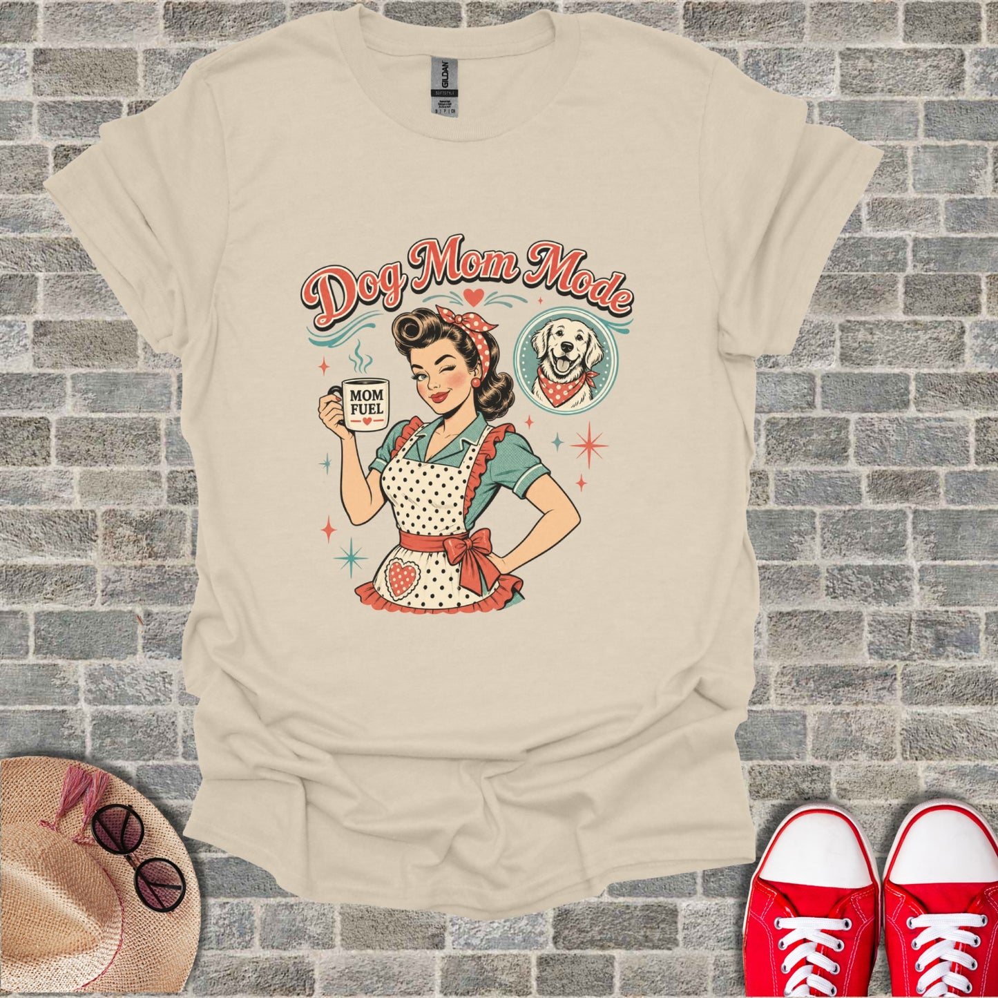 "Dog Mom Mode" graphic on a cream t-shirt with a retro woman holding "MOM FUEL" mug.