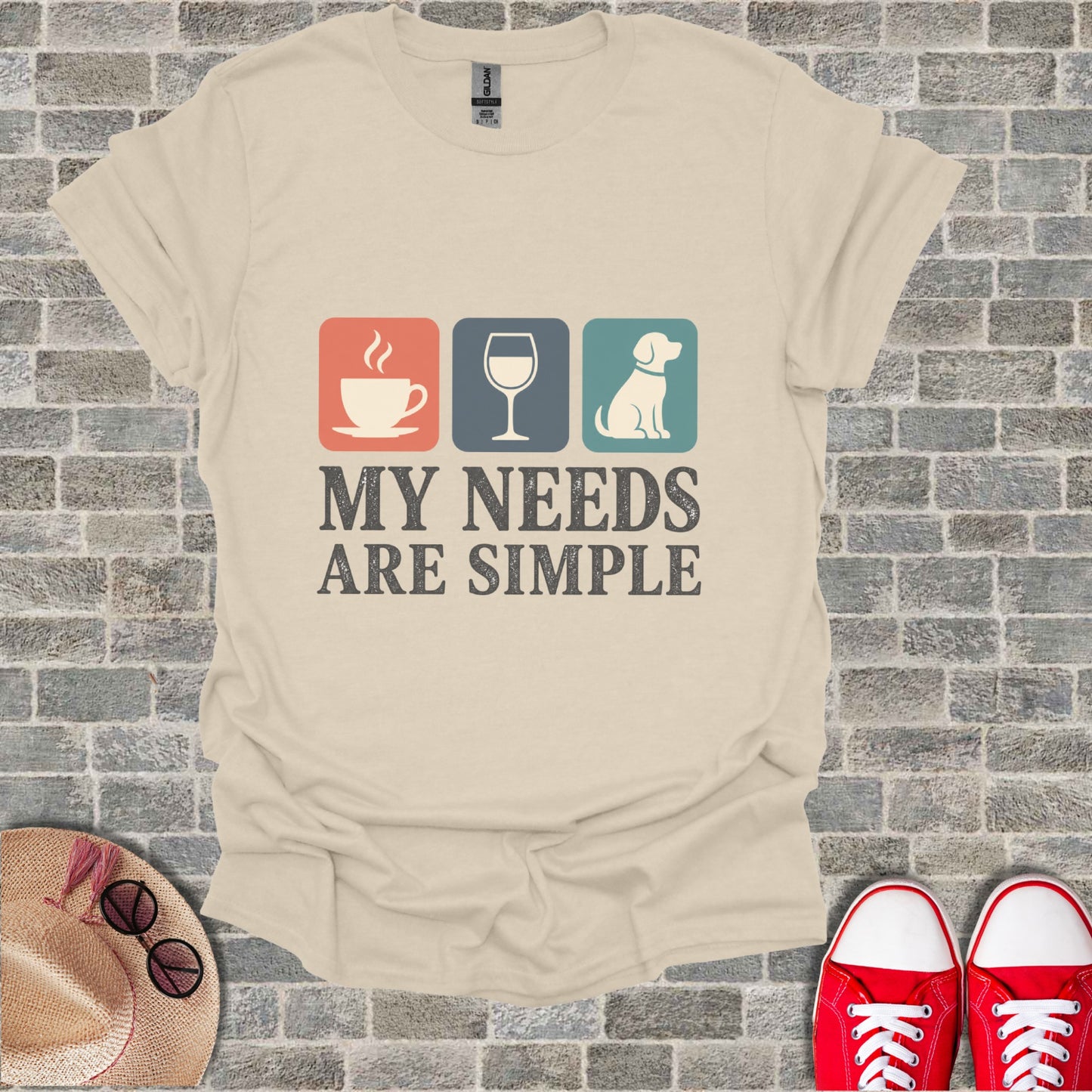Text graphic on T-shirt: coffee, wine, dog icons and "My Needs Are Simple".